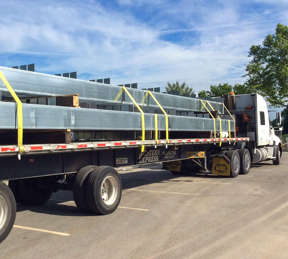 pre-engineered steel frame columns for carports are delivered for installation